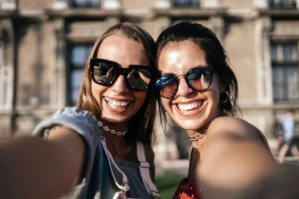 Jovens mulheres felizes em óculos de sol tomando selfie — Fotografia de Stock