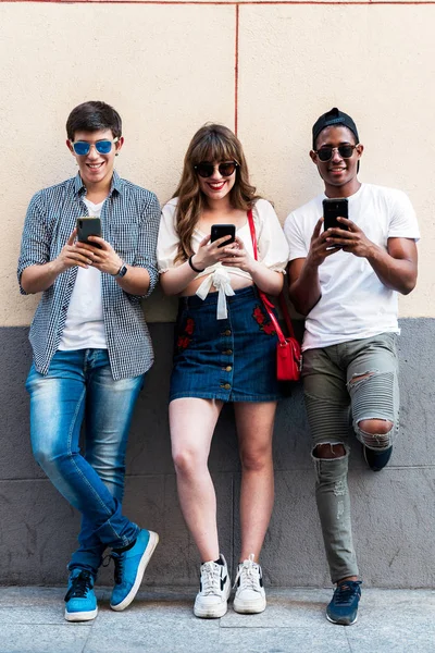 Multiraciale stijlvolle vrienden met smartphones op straat — Stockfoto