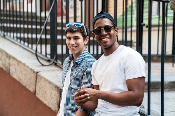 Multiracial men in sunglasses nearby metal fence — Stock Photo, Image