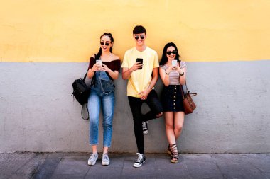 Cep telefonu kullanan bir grup genç arkadaş
