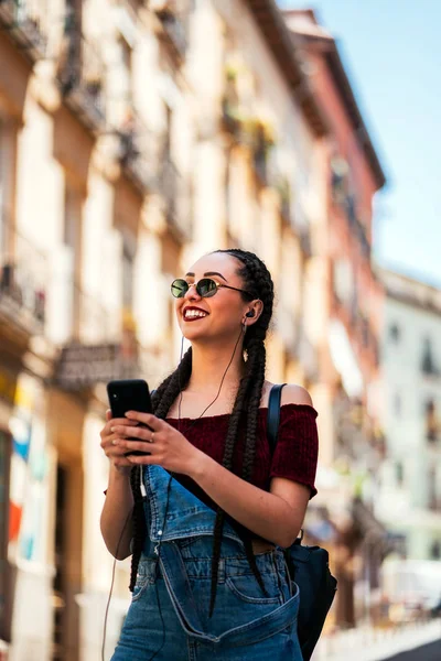 Mujer escribiendo teléfono móvil y escuchando música — Foto de Stock