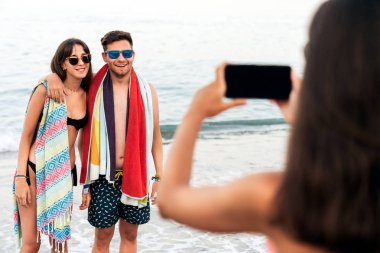 Plajda yüzdükten sonra çiftin fotoğrafını çeken kadın