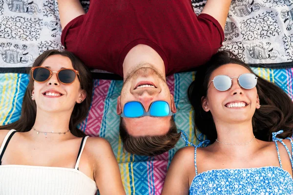 Lachende Freunde liegen zusammen auf Decke — Stockfoto