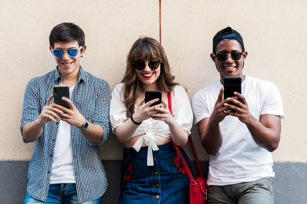 Amigos multiraciales con estilo con teléfonos inteligentes en la calle —  Fotos de Stock