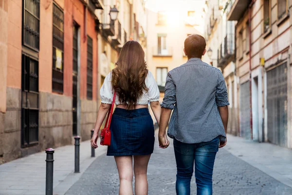 Stylish couple walking together along city street