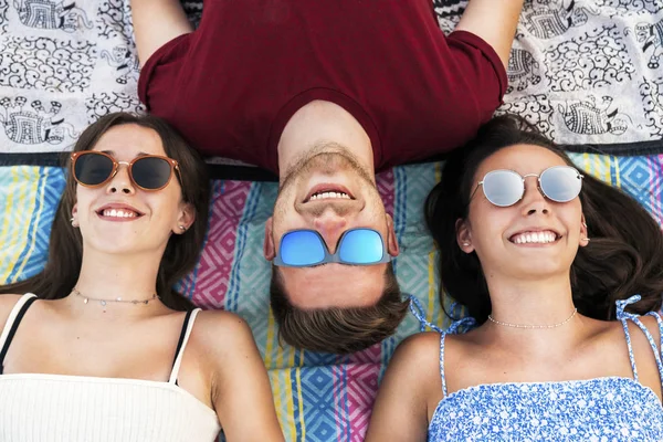 Lachende Freunde liegen zusammen auf Decke — Stockfoto