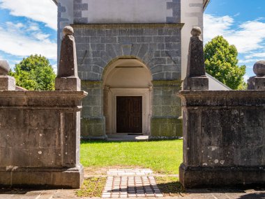 Lipica, Slovenya - 27 Temmuz 2025: Tahta kapıya açılan kemerli taş giriş.