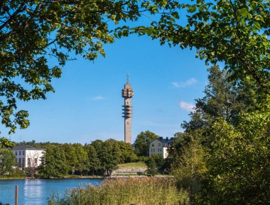 Stockholm, İsveç - 5 Eylül 2025: Ağaçların arasından görülebilen, berrak mavi gökyüzü olan yüksek bir kule