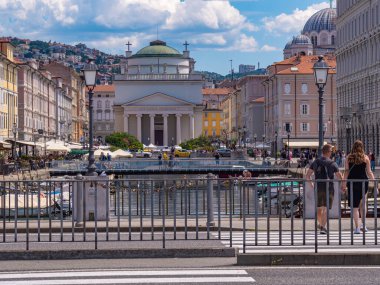 Trieste, İtalya - 1 Ağustos 2025: Kanalı, tarihi binaları ve kilisesi olan bir Avrupa şehrinin manzarası.
