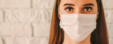 Banner 'ın kendine güveni tam, koruyucu maskeli kadın cerrah hastanede. Tıbbi maske takan genç hasta bir kadın. Hastalıklı kız yüz maskesi takıyor. Coronavirus COVID-19 koruması. Kişisel güvenlik