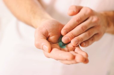 Coronavirus COVID-19 'a karşı korunmak için dezenfektanla ellerini ovuşturan genç bir doktor. Erkek elleri NCov-19 'a karşı önleyici sebep olarak antibakteriyel jelle ellerini yıkıyor ve uyguluyor.