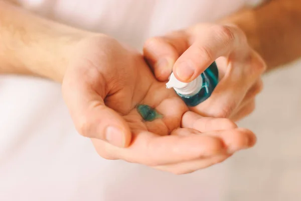 Closeup of doctor applying antibacterial gel on his palms as preventive measures against contagious virus diseases. Man using sanitizer from dispenser on his hand. nCov-19, COVID-19, Coronavirus