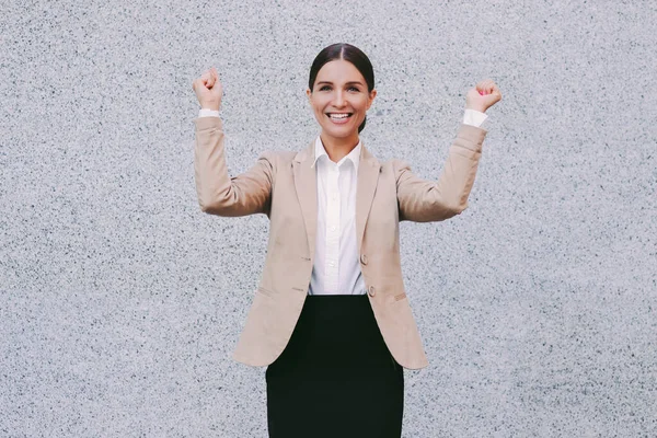 Portrait happy beautiful business woman in suit point with index fingers up to copy space on gray background and smile. Attractive young millennial girl successful entrepreneur gesture on copy space