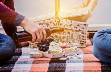 Dışarıda romantik bir akşam. Gündelik giyinen genç bir adamın, kız arkadaşıyla dışarıda otururken bardaklara şarap dökerek yakınlaşması. Genç çift yıldönümünü kutluyor. Temiz havada piknik..