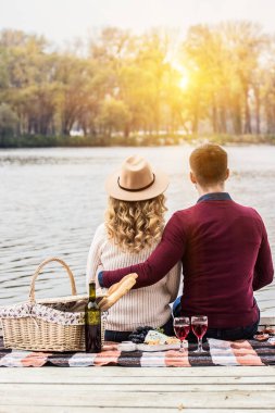 Her zaman birlikte olacağız. Sahilde romantik piknik yapan bir adamın güzel kadınını kucaklamasının arkası. Genç bir çift dışarıda romantik bir akşam yemeği sırasında şarap içiyor..