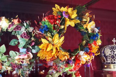 Wreath with sunflowers, poppies, daisies and cornflowers hanging on the stand