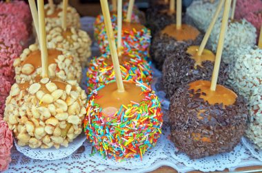 Dükkan penceresinde çikolata, şekerleme ve şekerleme meyve ile dekore karamel ile Noel pişmiş elma,