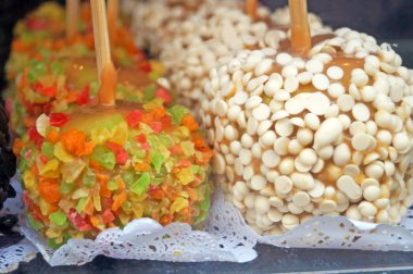 Dükkan penceresinde çikolata, şekerleme ve şekerleme meyve ile dekore karamel ile Noel pişmiş elma,