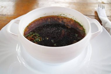 Mantar çorbası ahşap bir masa üzerinde beyaz bir tabakta otlar ile tatlandırılmış