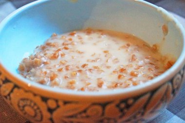 Haşlanmış yulaf ezmesi sabah şenlikli tuz dekoratif bir mavi plaka içine dökülür