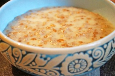 Haşlanmış yulaf ezmesi sabah şenlikli tuz dekoratif bir mavi plaka içine dökülür