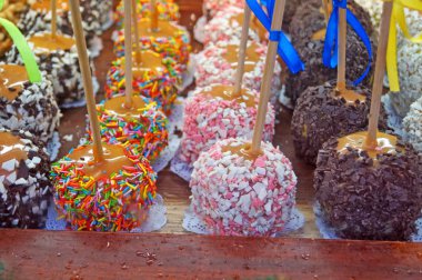 Dükkan penceresinde çikolata, şekerleme ve şekerleme meyve ile dekore karamel ile Noel pişmiş elma,