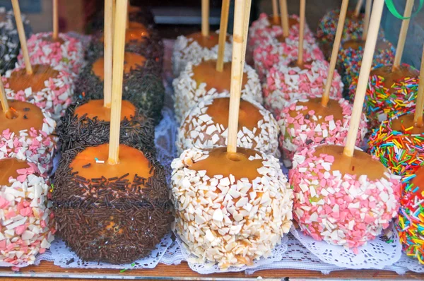 Dükkan penceresinde çikolata, şekerleme ve şekerleme meyve ile dekore karamel ile Noel pişmiş elma,