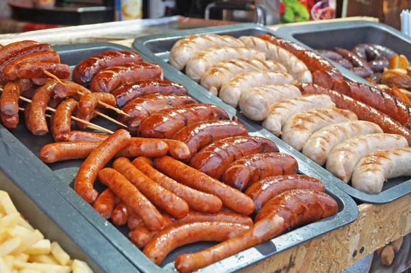 Güneşli bir günde fuarda tezgahta ızgara sosis, ev yapımı sosis ve kupaty