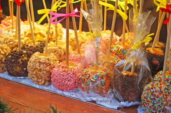 クリスマスはキャラメルでリンゴを焼き 店の窓にはチョコレート キャンディー キャンディー キャンディーフルーツで飾られています — ストック写真