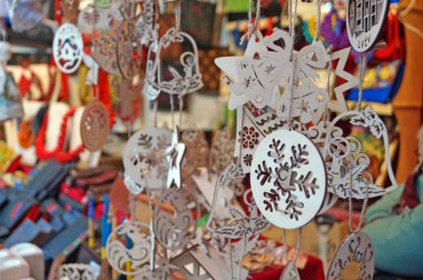 Bir festival fuarında bir tezgah üzerinde asılı Ahşap Noel ağacı süslemeleri