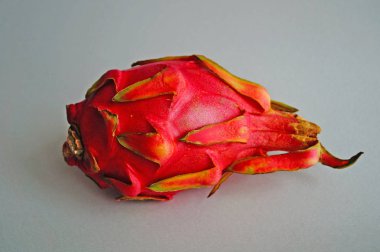 Hafif bir arka plan üzerinde siyah tohumlar ile pembe kabuğu ve sulu beyaz hamuru ile Ejderha meyve veya pitaya