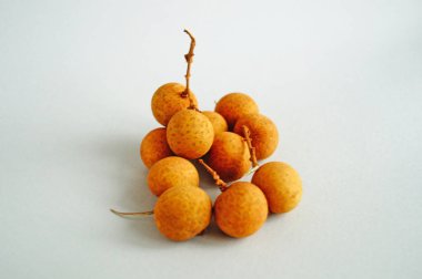 Hafif bir arka plan üzerinde ince sarı kabuk ile longan meyve bir demet