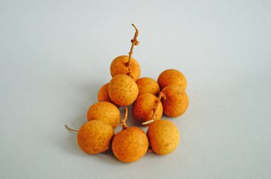 Hafif bir arka plan üzerinde ince sarı kabuk ile longan meyve bir demet