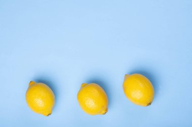 Mavi arka planda üç taze limon