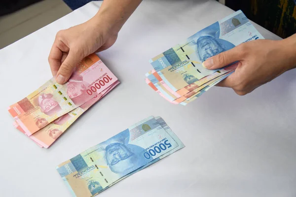 Perempuan Memisahkan 100 000 Dan 000 Rupiah Indonesia — Stok Foto