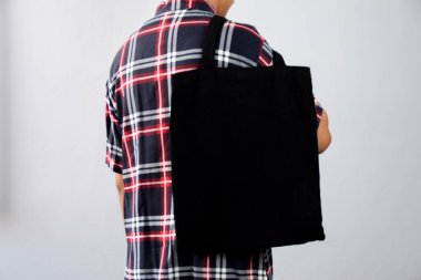 Man Holding Black Blank Taşıma Çantası Model tasarımı için kullanılıyor