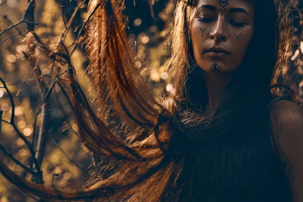 Genç güzel boho kadın portarait gün batımında sahilde geleneksel süsleme ile