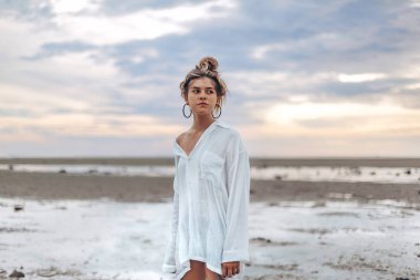 gün batımında sahilde güzel genç boho tarzı kız. Genç doğal moda model açık havada dikey