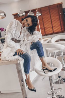 Villa mutfak masasında oturan neşeli genç kadın