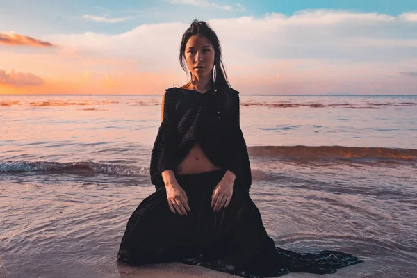 Gün Batımında Kuma Oturan Moda Genç Kadın Modeli — Stok fotoğraf