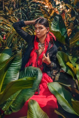 güzel genç moda kadınla telafi etmek ve doğal tropikal arka plan üzerinde poz şık boho aksesuarları