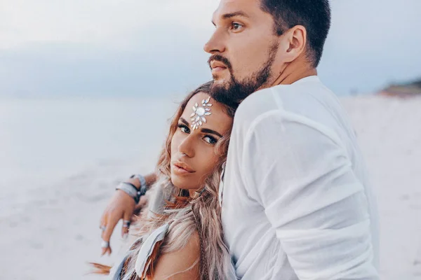 Belo jovem casal na praia ao pôr do sol. — Fotografia de Stock