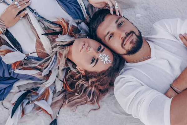 Belo jovem casal deitado na areia na praia . — Fotografia de Stock