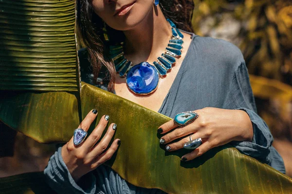 Close up de jovem mulher vestindo jóias de pedra preciosa ao ar livre — Fotografia de Stock