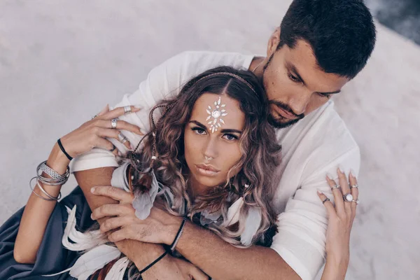 Belo jovem casal deitado na areia na praia . — Fotografia de Stock