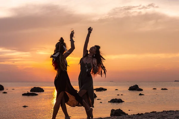 Silueta de dos chicas hermosas jóvenes divirtiéndose en la playa — Foto de Stock