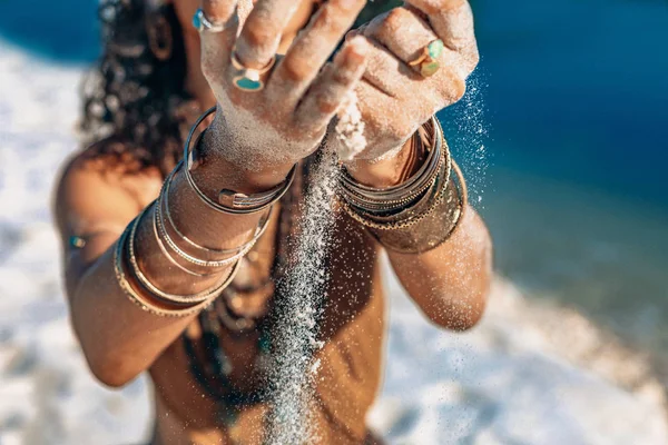 Bela jovem segurando areia em suas mãos na praia — Fotografia de Stock