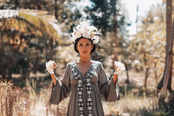 Schöne junge Frau mit Kranz aus Frangipani-Blumen — Stockfoto
