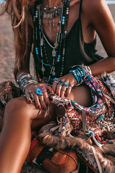 Primer plano de la joven mujer de estilo boho sentada en la arena en la playa — Foto de Stock