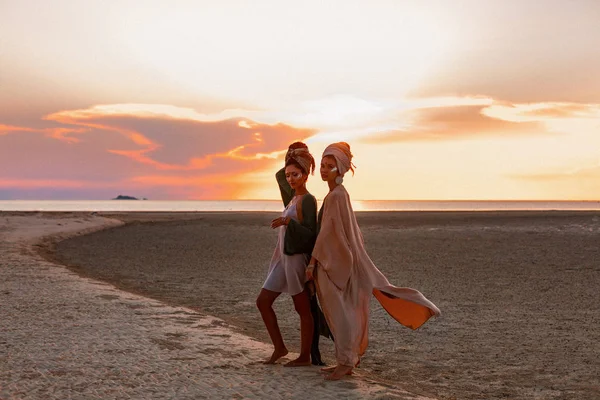 Silueta de dos chicas hermosas jóvenes en turbante en la playa — Foto de Stock